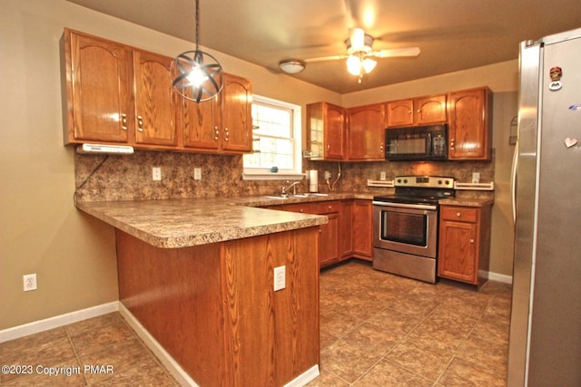 158 Davis Cir, Bushkill, PA 18324 - kitchen featuring stainless steel appliances, a peninsula, brown cabinetry, ceiling fan, and tasteful backsplash