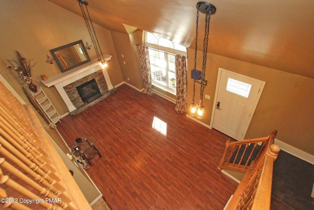 158 Davis Cir, Bushkill, PA 18324 - unfurnished living room featuring vaulted ceiling, a stone fireplace, and wood finished floors
