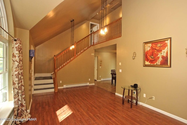 158 Davis Cir, Bushkill, PA 18324 - unfurnished living room featuring a baseboard radiator, wood finished floors, stairs, and high vaulted ceiling