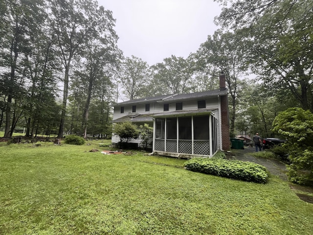 122 Savage Trl, East Stroudsburg, PA 18301 - rear view of property featuring a chimney, a sunroom, and a yard
