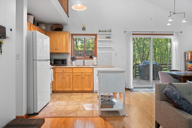 130 Ruffed Grouse Rd, Bushkill, PA 18324 - kitchen featuring freestanding refrigerator, a high ceiling, black microwave, light countertops, and decorative backsplash