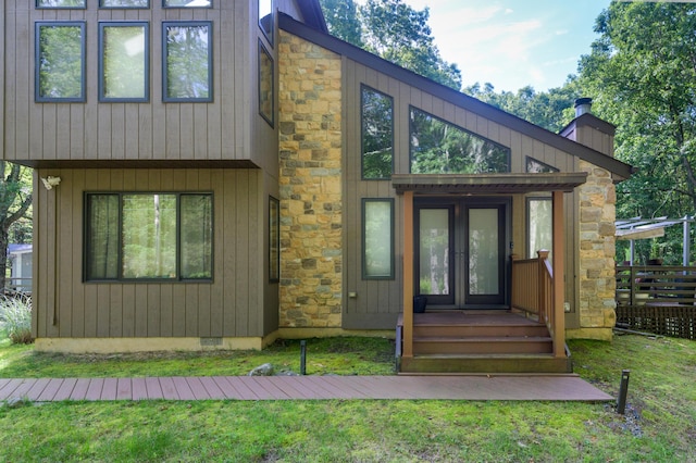 130 Ruffed Grouse Rd, Bushkill, PA 18324 - view of front of property with french doors, a chimney, stone siding, and a front lawn