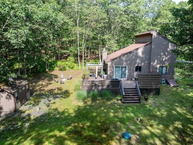 130 Ruffed Grouse Rd, Bushkill, PA 18324 - rear view of property with a deck, a yard, a chimney, and a wooded view