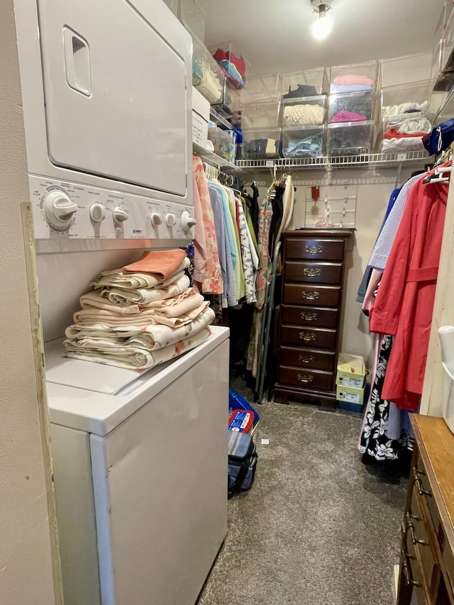 walk in closet with stacked washing maching and dryer and carpet floors