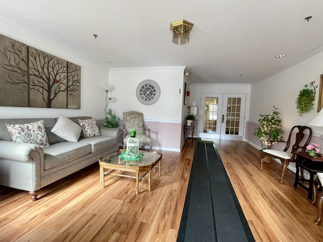 living area with ornamental molding, french doors, light wood-style floors, and baseboards