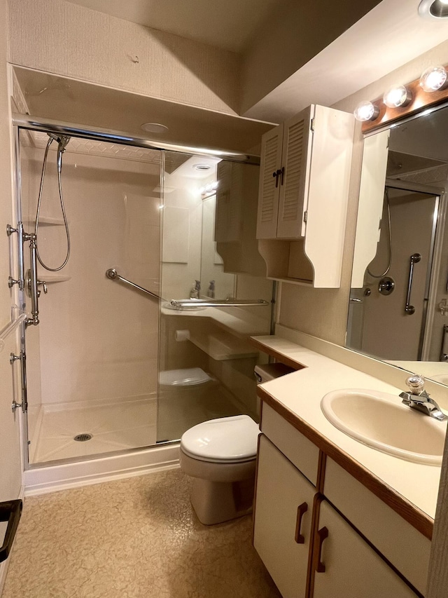 bathroom with toilet, a stall shower, and vanity