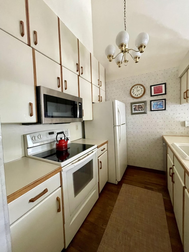 kitchen with wallpapered walls, dark wood-style floors, white appliances, light countertops, and baseboards