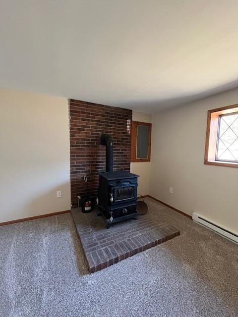 interior details with a wood stove, carpet flooring, baseboards, and baseboard heating