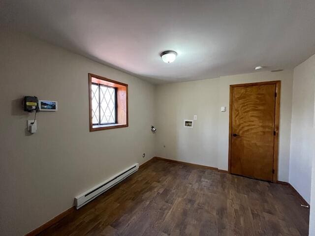 spare room with wood finished floors and a baseboard radiator