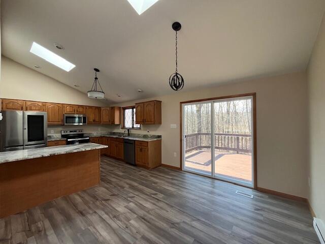 kitchen featuring a skylight, brown cabinets, and stainless steel appliances