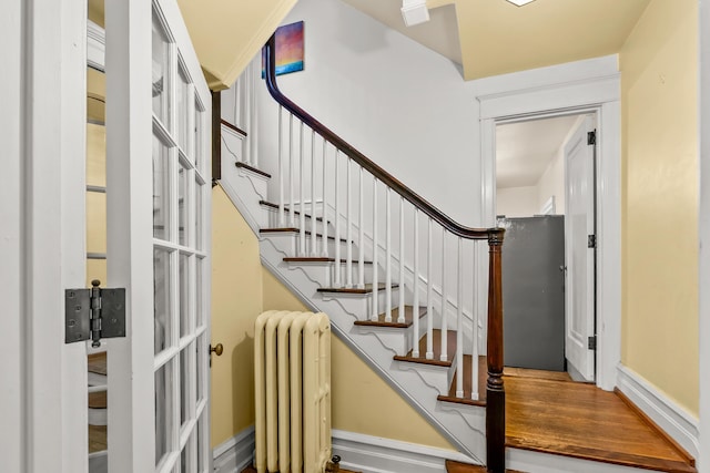 staircase with baseboards and radiator