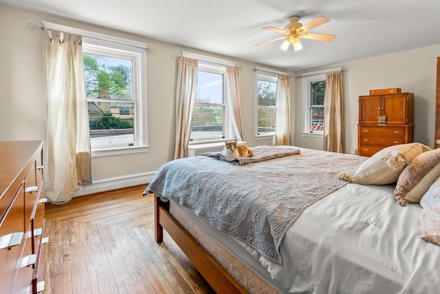 bedroom featuring baseboards, ceiling fan, and light wood-style flooring