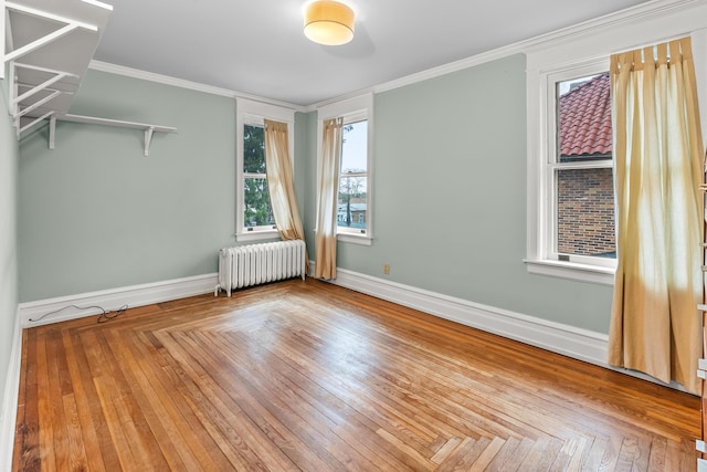 spare room featuring baseboards, ornamental molding, and radiator heating unit