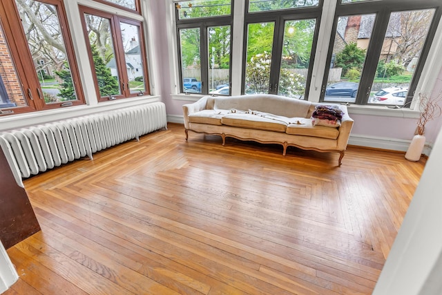sunroom / solarium featuring plenty of natural light, radiator, and a deck