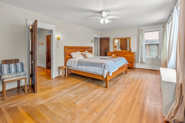 bedroom featuring baseboards, light wood finished floors, and ceiling fan