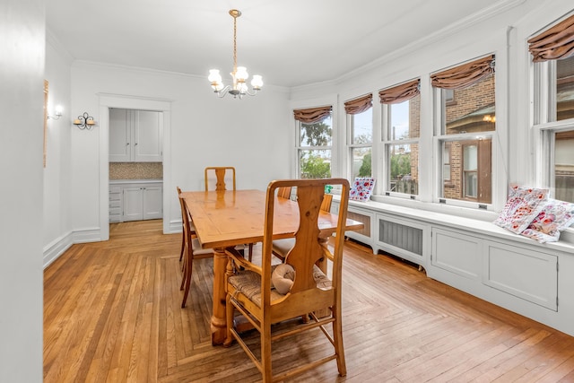 dining area featuring crown molding, baseboards, and a notable chandelier