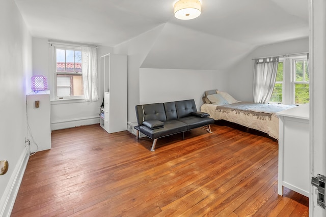 bedroom with baseboards, lofted ceiling, multiple windows, and hardwood / wood-style floors