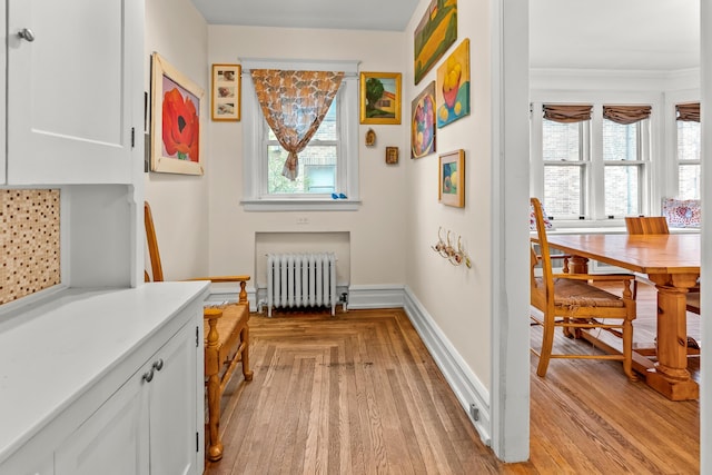 interior space featuring crown molding, radiator, and baseboards