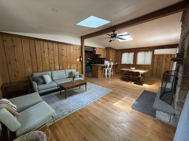1827 Stag Run, Pocono Lake, PA 18347 - living room with a skylight, wooden walls, a wall unit AC, light wood-style flooring, and ceiling fan