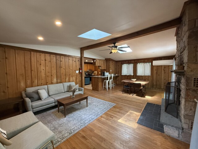 1827 Stag Run, Pocono Lake, PA 18347 - living area featuring a skylight, wooden walls, light wood finished floors, a wall mounted air conditioner, and ceiling fan