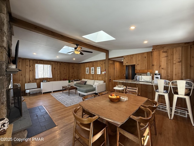 1827 Stag Run, Pocono Lake, PA 18347 - dining room featuring vaulted ceiling with skylight, wood walls, a ceiling fan, and hardwood / wood-style flooring
