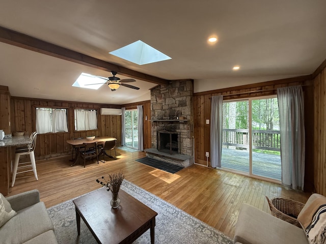 1827 Stag Run, Pocono Lake, PA 18347 - living room with a skylight, light wood-style flooring, wooden walls, an AC wall unit, and a fireplace