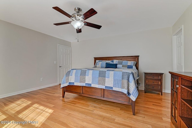 bedroom featuring baseboards, ceiling fan, and light wood finished floors