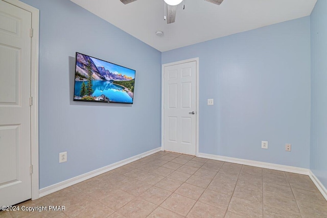 unfurnished room featuring light tile patterned floors, a ceiling fan, and baseboards