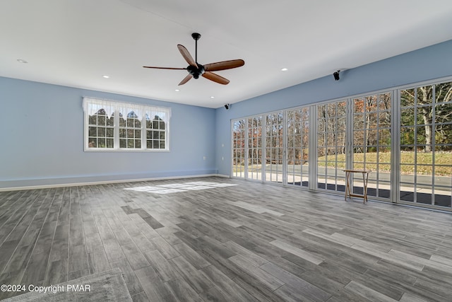 empty room with a ceiling fan, baseboards, wood finished floors, and recessed lighting