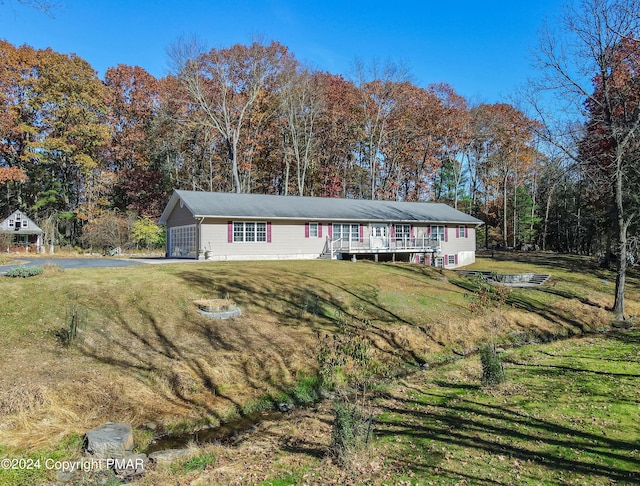 single story home featuring a front yard and a wooden deck