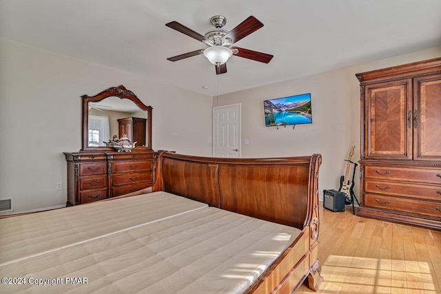 bedroom with a ceiling fan, visible vents, and light wood finished floors