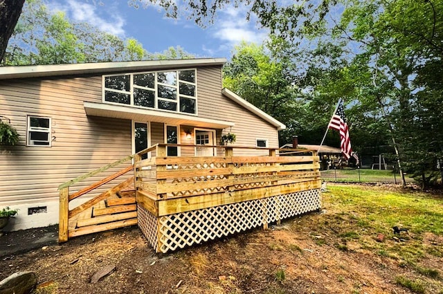 back of house with crawl space and a wooden deck