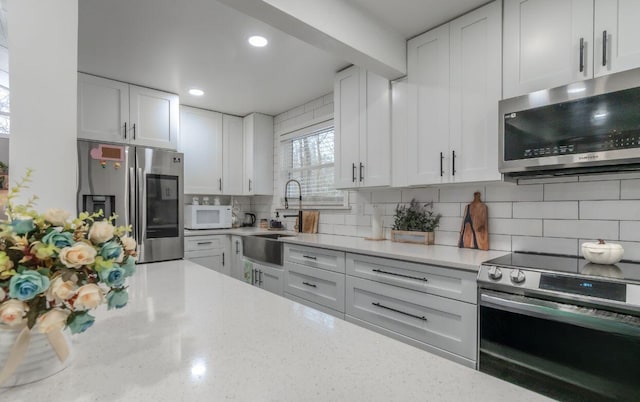 352 Scotch Pine Dr, Pocono Summit, PA 18346 - kitchen with stainless steel appliances, a sink, decorative backsplash, white cabinets, and recessed lighting
