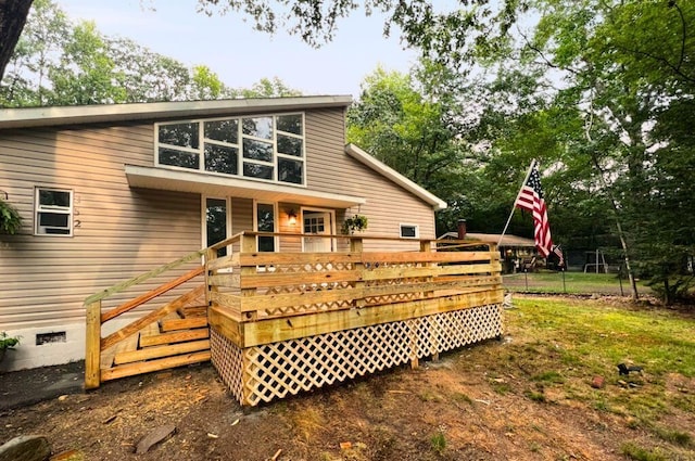 back of house featuring crawl space and a wooden deck