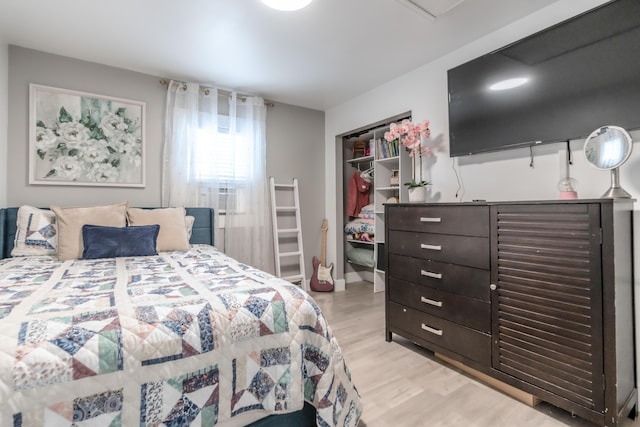 bedroom featuring light wood-style floors, a closet, and cooling unit