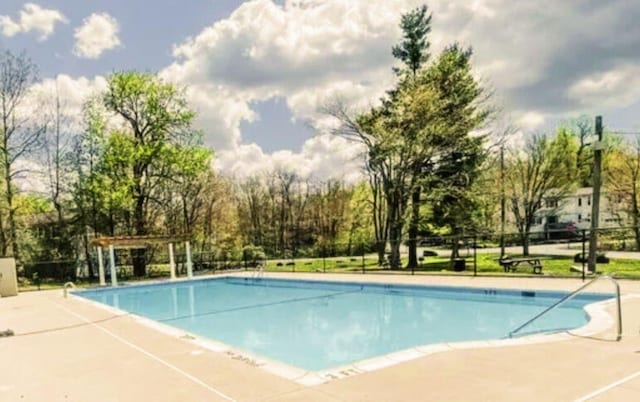 community pool featuring a patio, fence, and a pergola