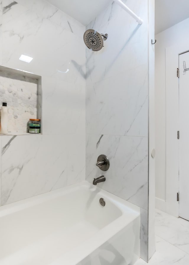 bathroom with marble finish floor and shower / tub combination