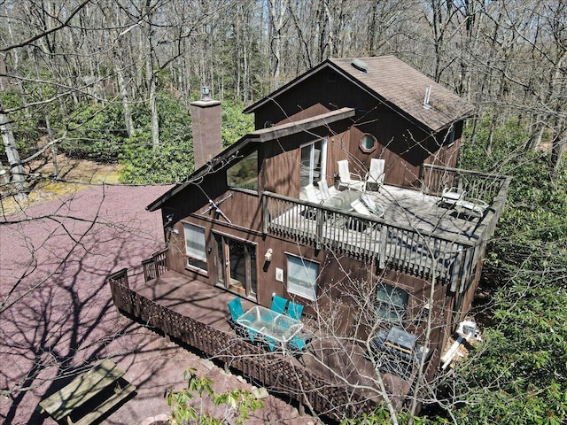 view of property exterior featuring a forest view and a chimney