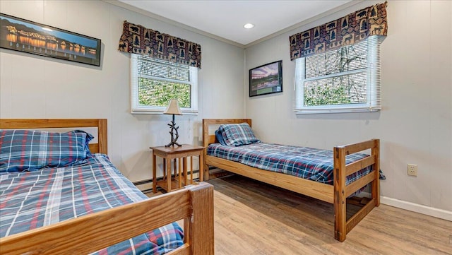 bedroom featuring recessed lighting, baseboards, ornamental molding, and wood finished floors