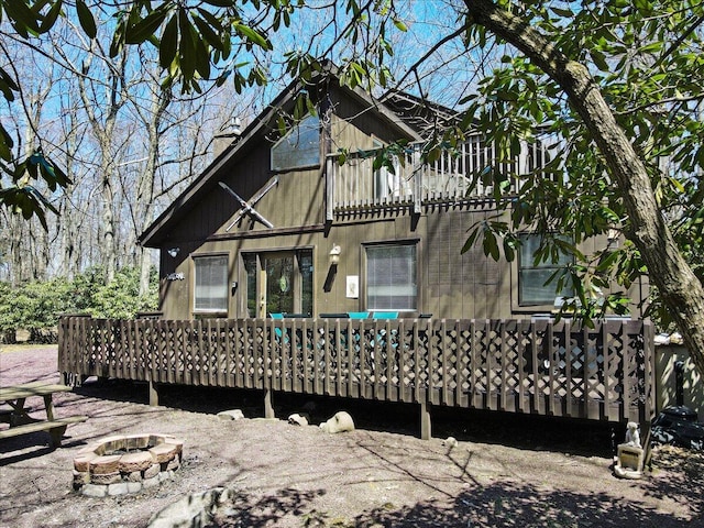 rear view of house with a deck and a fire pit