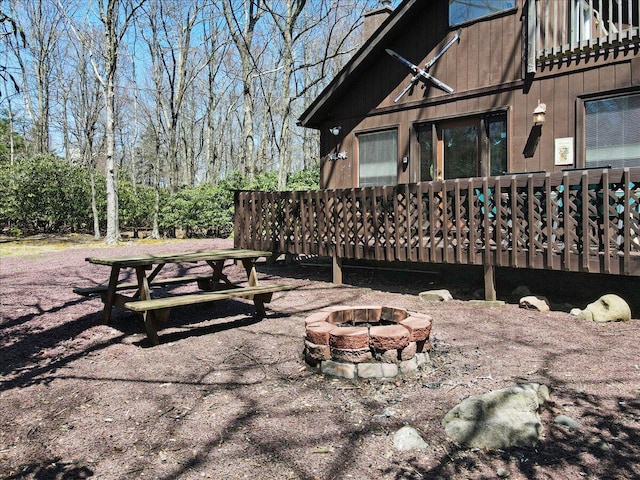 view of yard featuring a deck and an outdoor fire pit