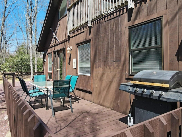 wooden terrace with outdoor dining space and area for grilling