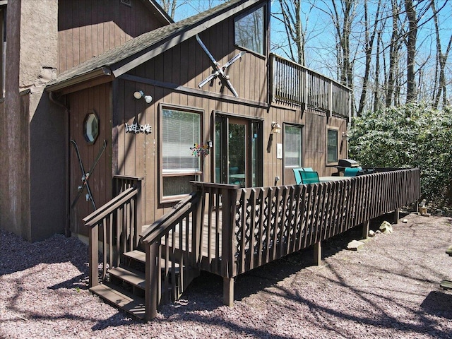 rear view of house with roof with shingles