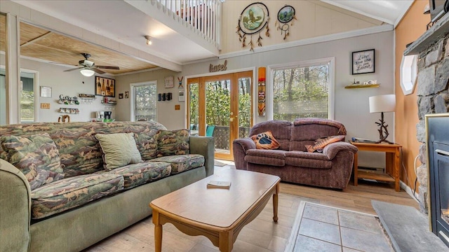 living room featuring a ceiling fan, french doors, crown molding, beamed ceiling, and light wood finished floors