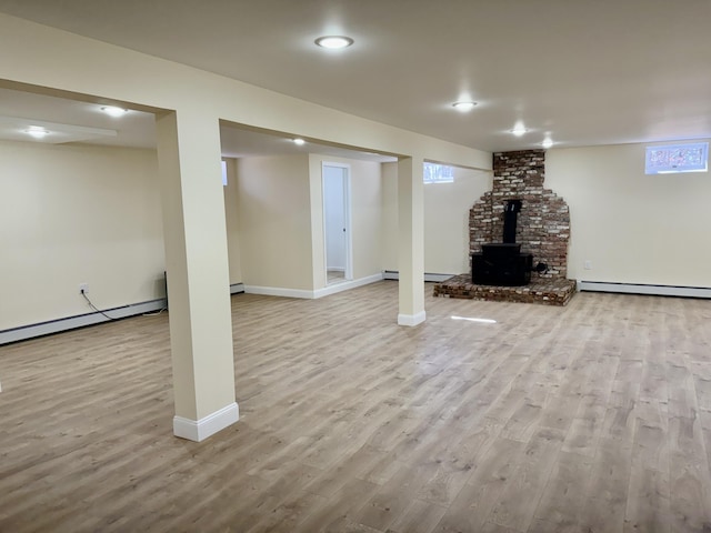 basement featuring baseboard heating, wood finished floors, and baseboards