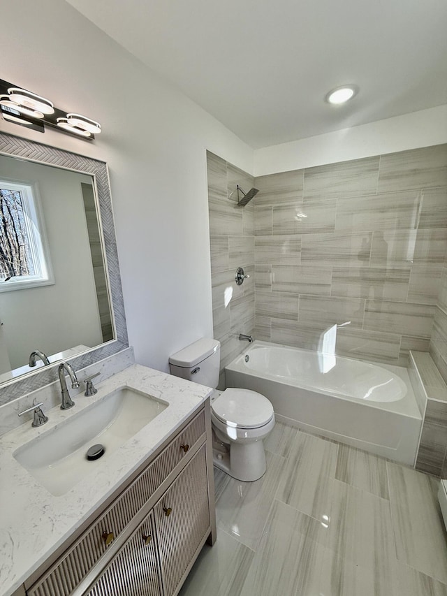 bathroom featuring toilet, vanity, and shower / bathing tub combination