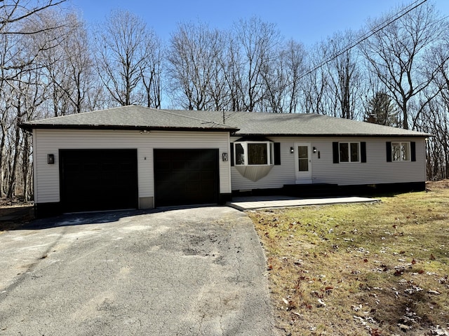 ranch-style house featuring aphalt driveway and an attached garage