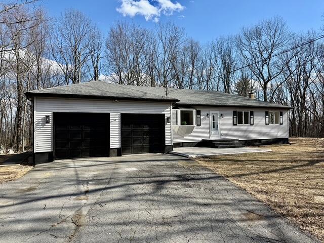 single story home featuring an attached garage and aphalt driveway