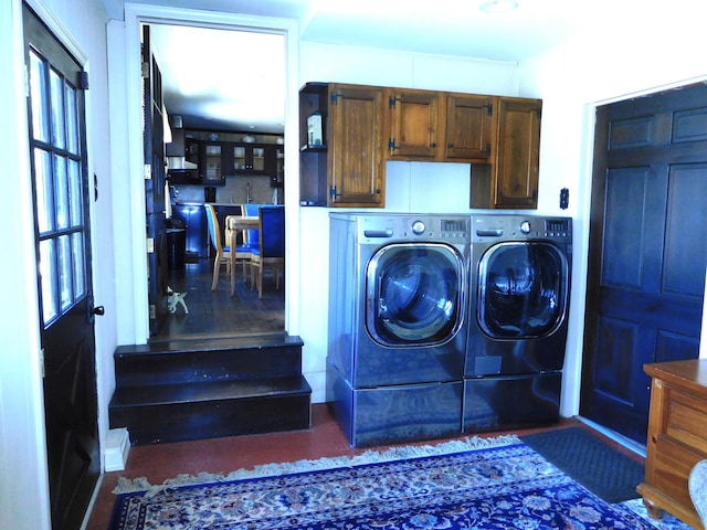 washroom with cabinet space and washing machine and dryer