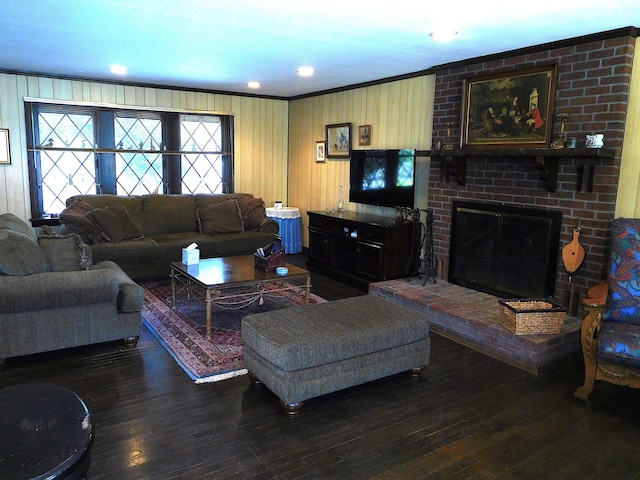 living room with wooden walls, ornamental molding, hardwood / wood-style flooring, and a fireplace